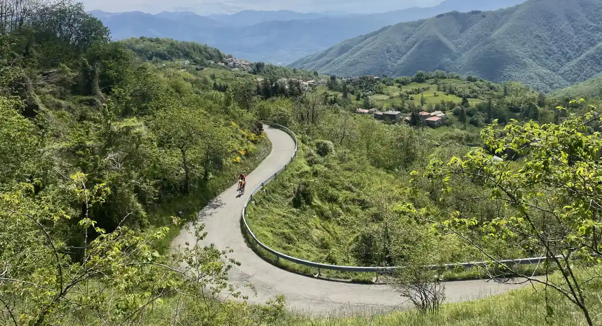 Cyclist climbing a winding road in the Apennine mountains near Parma