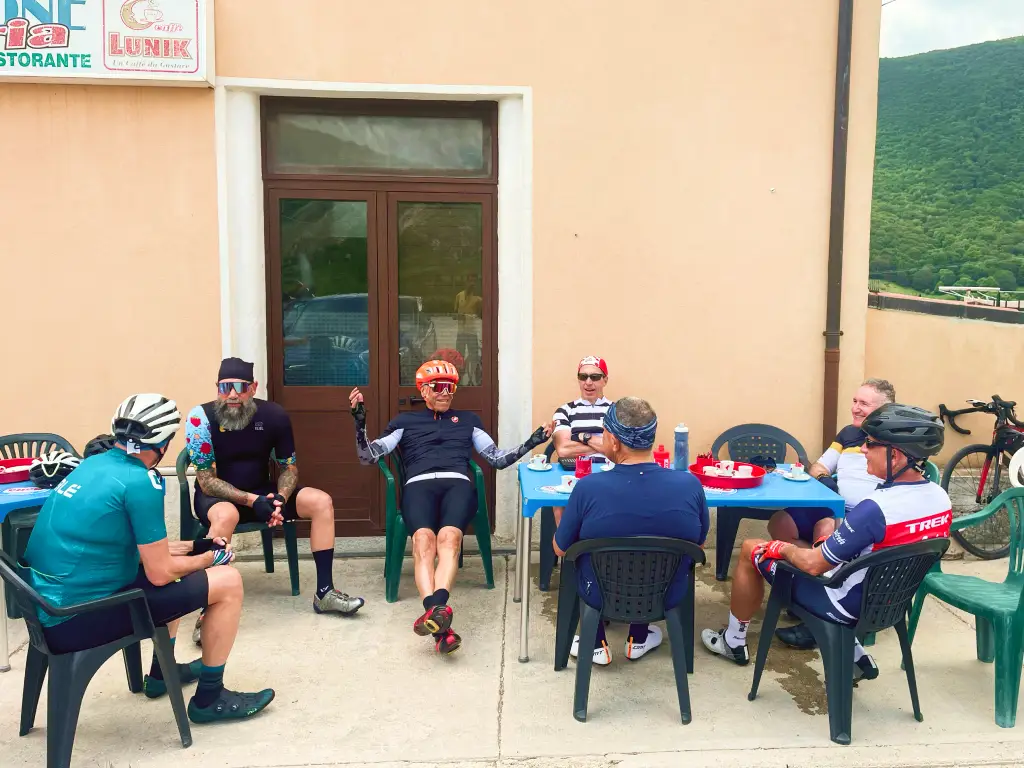 Group of cyclists relaxing at a small-town café in Abruzzo during a coffee stop