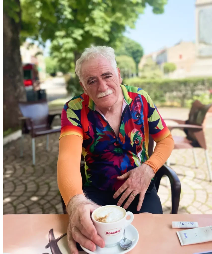 Smiling cyclist enjoying a cappuccino at an Italian bar after the ride