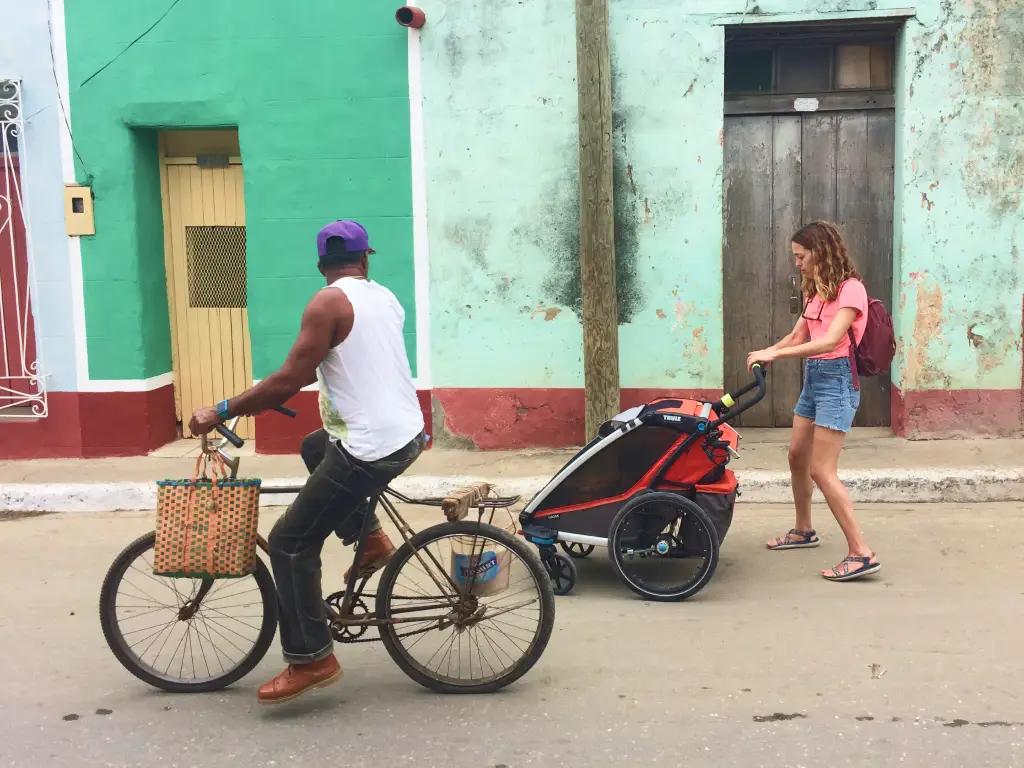 Woman pushing a stroller through the cobblestone streets of Trinidad, Cuba