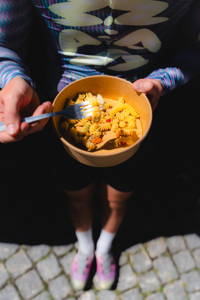 A cyclist refuels with a bowl of home cooked pasta before the second climb of Stelvio Pass