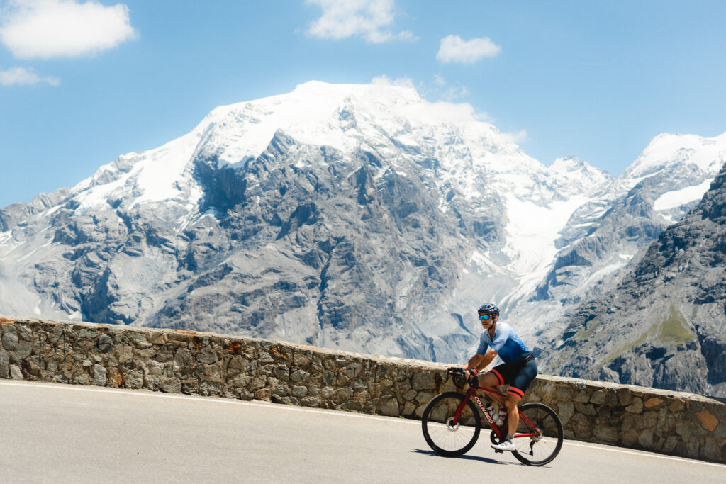 A cyclist climbing the Stelvio Pass with a great view over the Ortler mountains